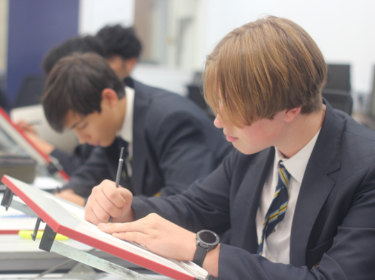 A group of young men writing on a book

Description automatically generated