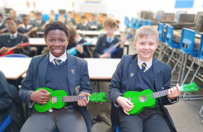 A group of boys in school uniforms holding green ukuleles

Description automatically generated