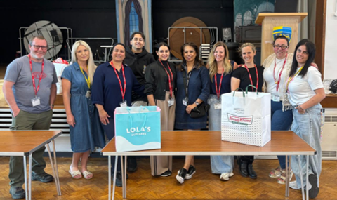 A group of people standing in front of a table

AI-generated content may be incorrect.