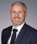 A person in a suit and tie

AI-generated content may be incorrect.