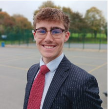 A person in a suit and tie

AI-generated content may be incorrect.